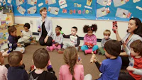a group of children sitting on the floor in a classroom